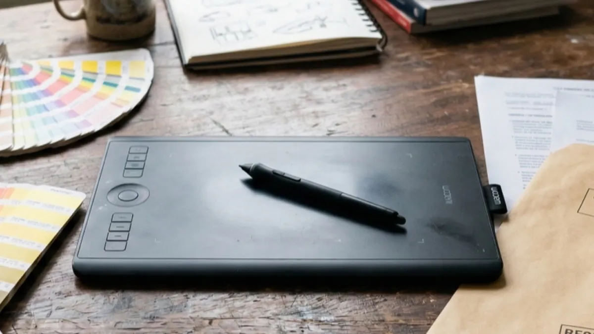 Tablette graphique, nuanciers et dossier de cession de droits sur un bureau de graphiste